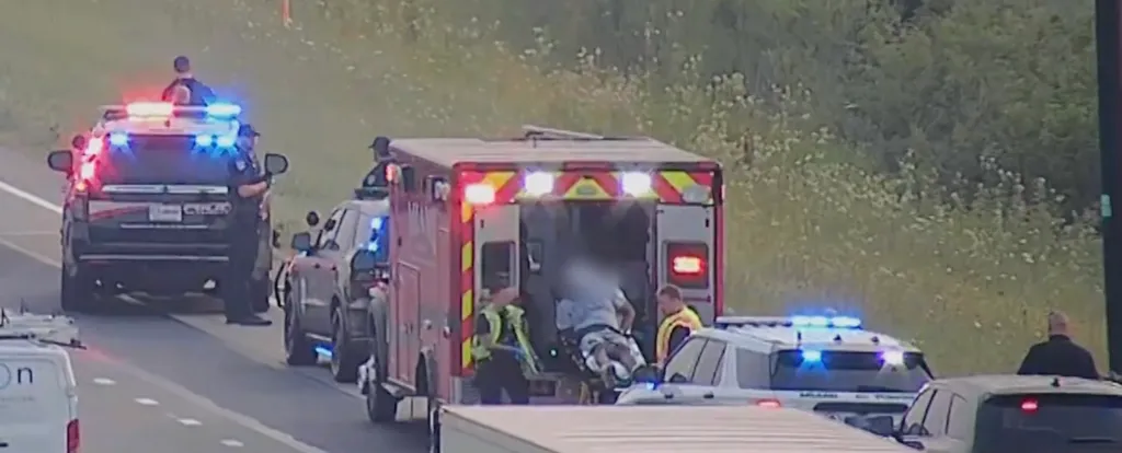 Emergency personnel attending to an incident on the side of a highway.