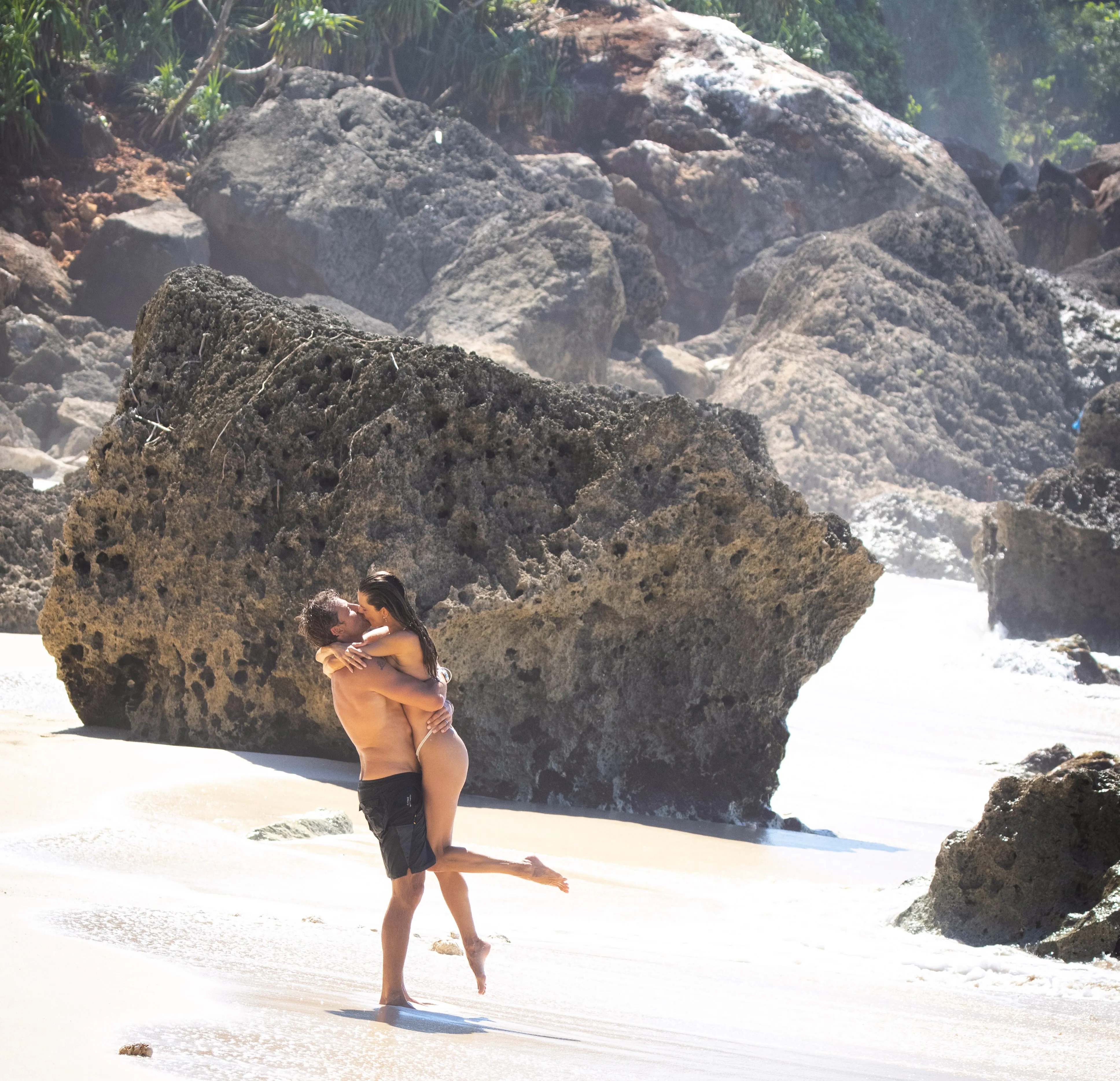 Alessandra Ambrosio and Buck Palmer kissing on a beach.