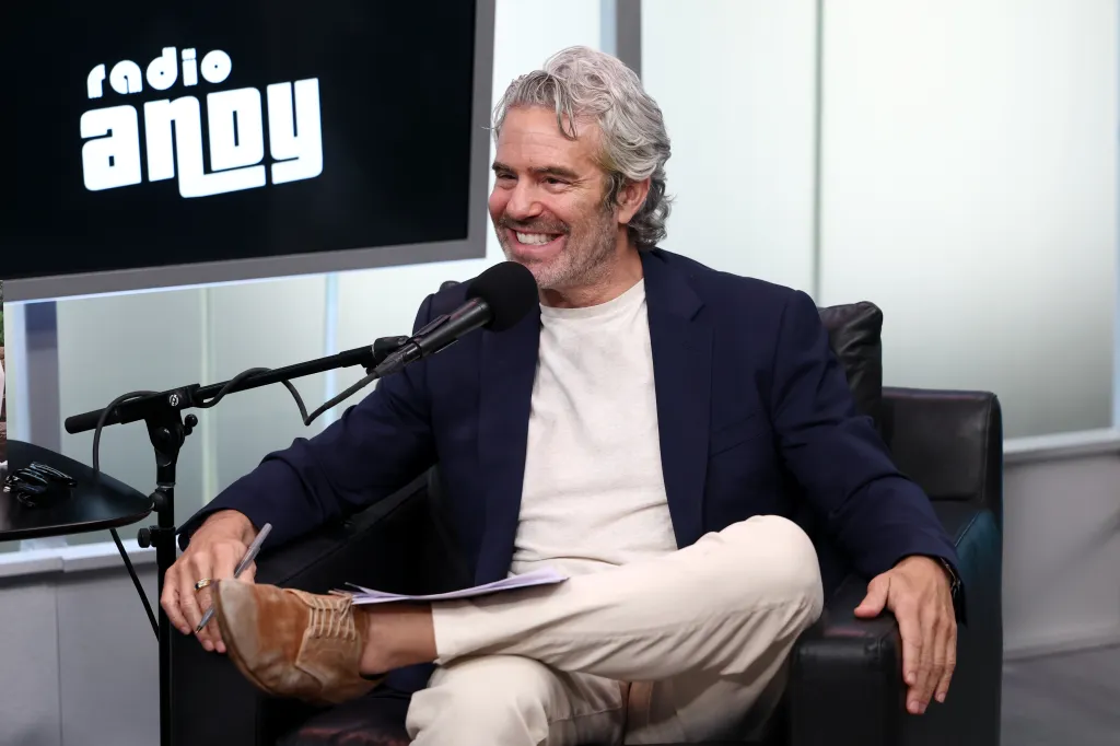 Andy Cohen seated and smiling at SiriusXM Studios.