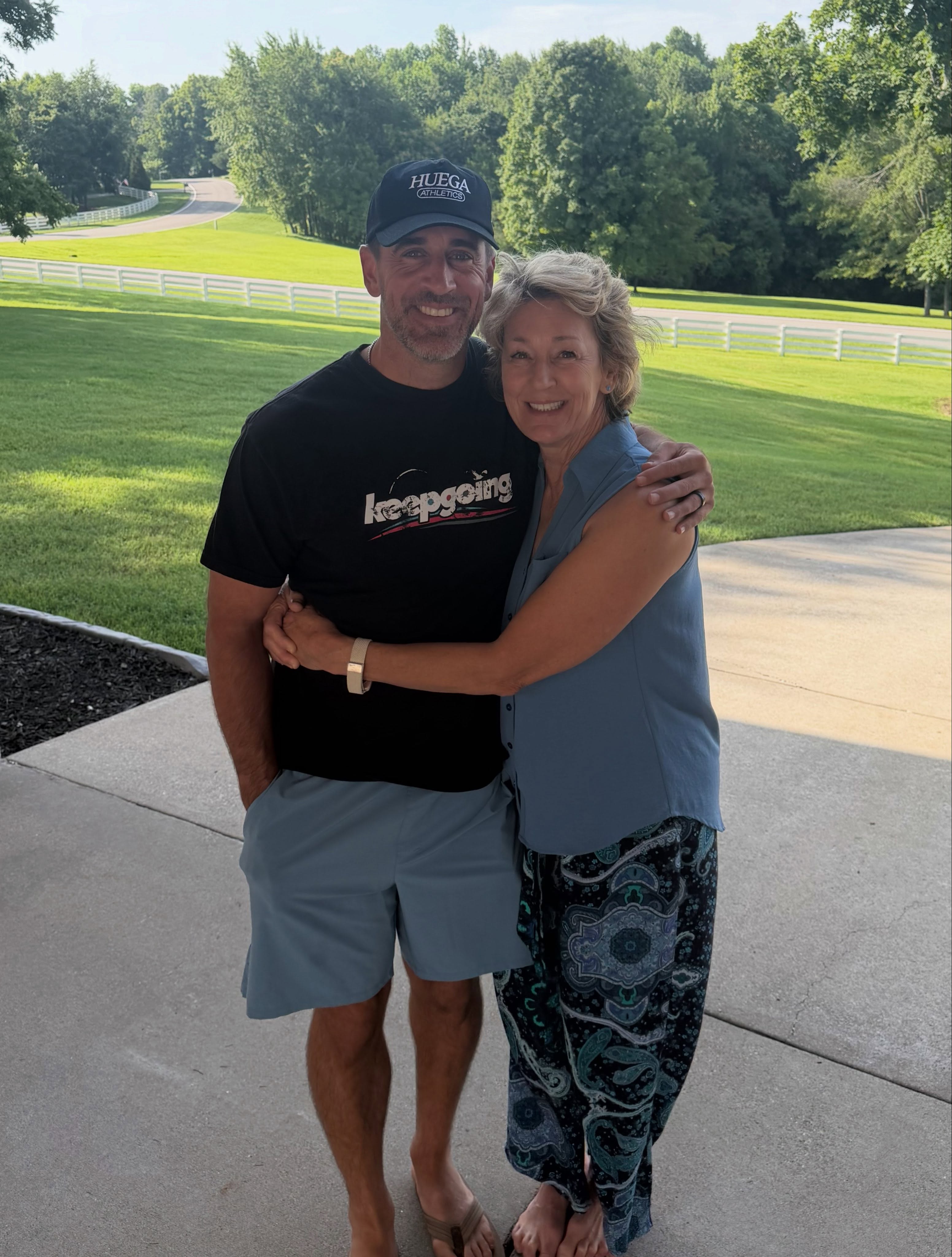 Aaron Rodgers and a woman embracing.