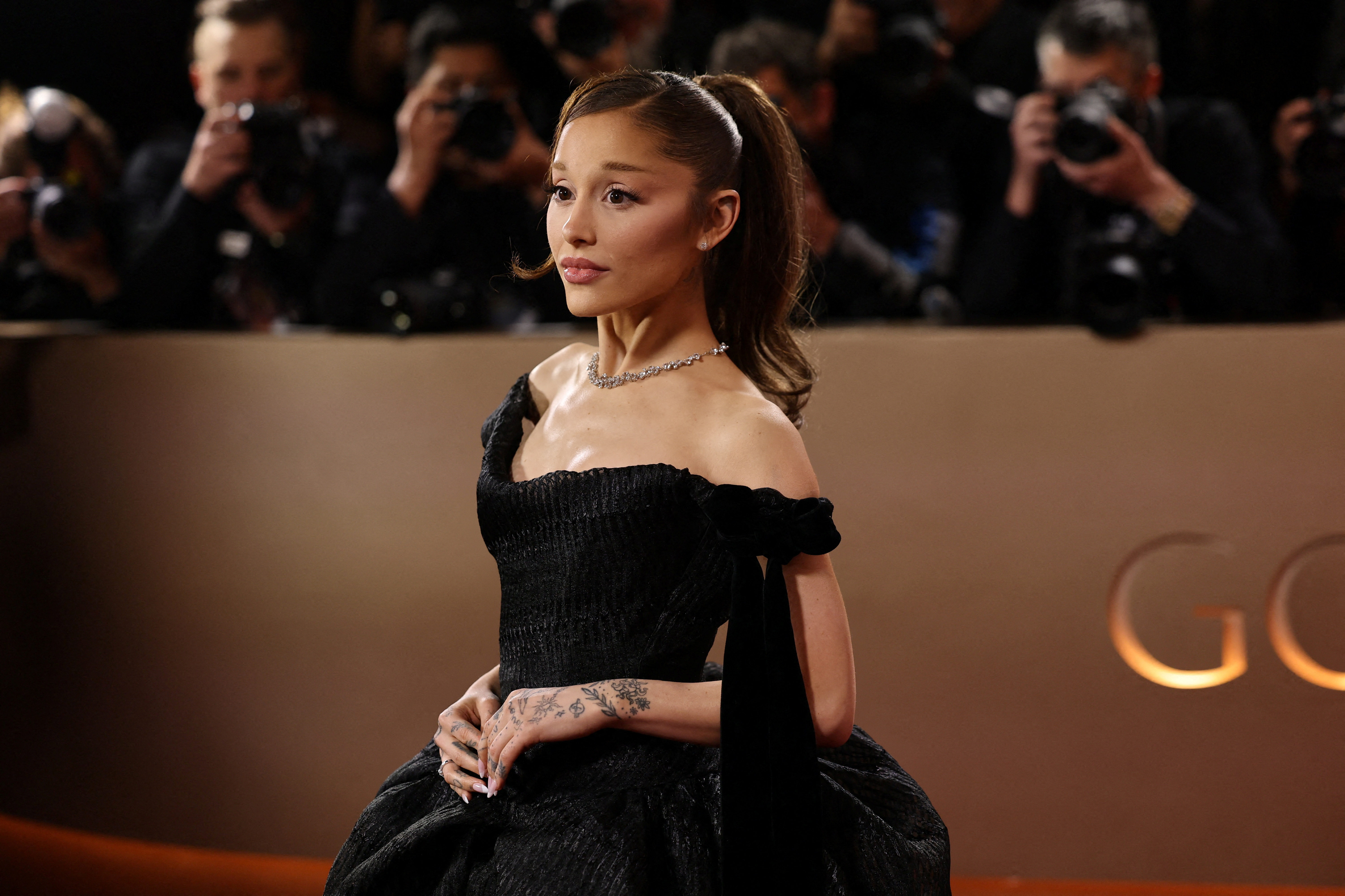 Ariana Grande posing on the red carpet at the 83rd Annual Golden Globes.
