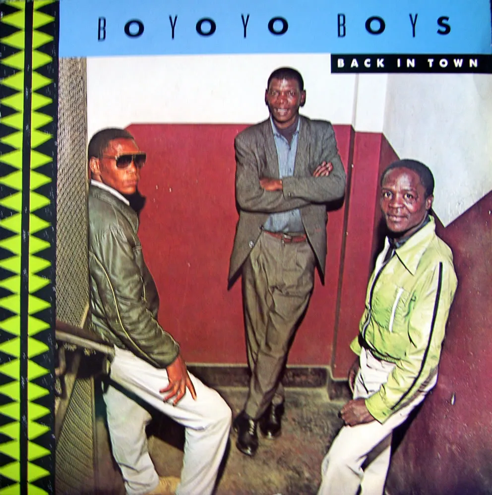 Album cover for "Boyoyo Boys Back in Town" showing three men standing.