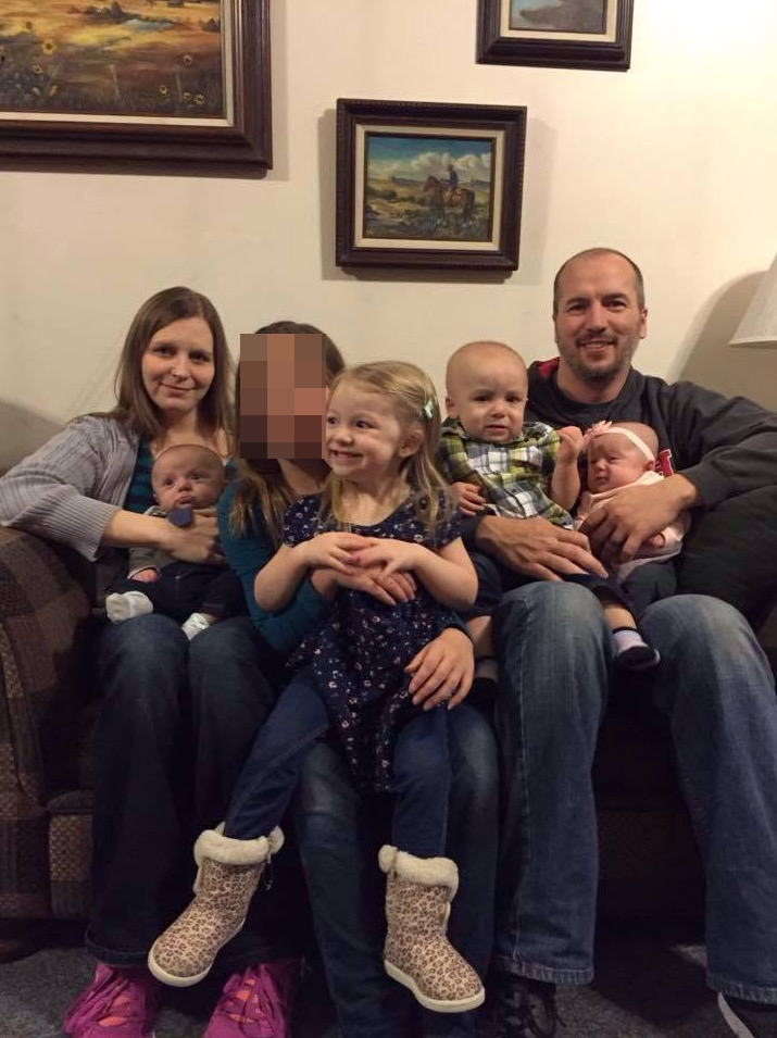 Brady Harmon and another adult sit on a couch with four young children.