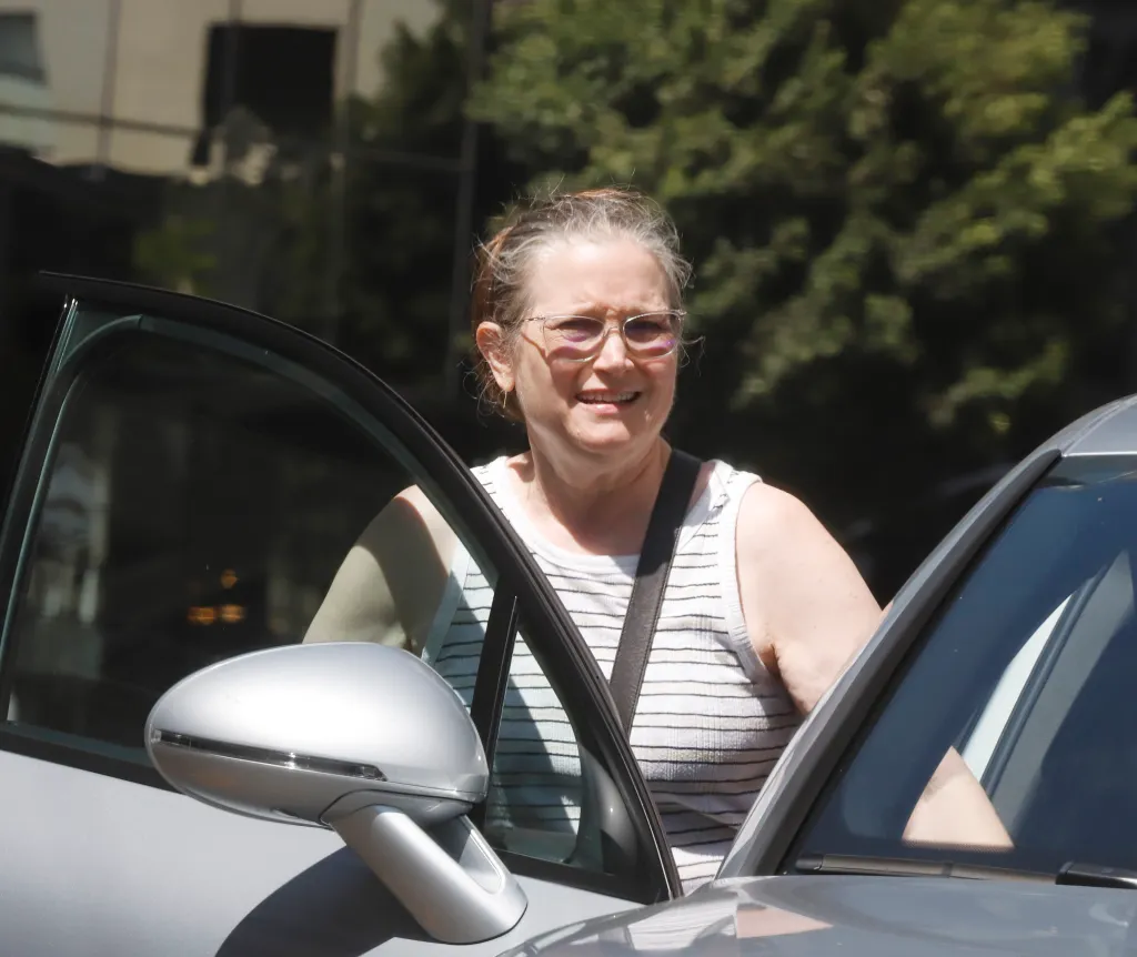 Bridget Fonda smiling while exiting a car.