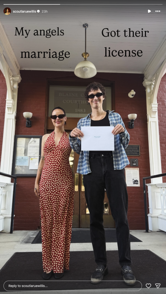 Scout Willis and her partner standing outside a courthouse, holding up their marriage license.