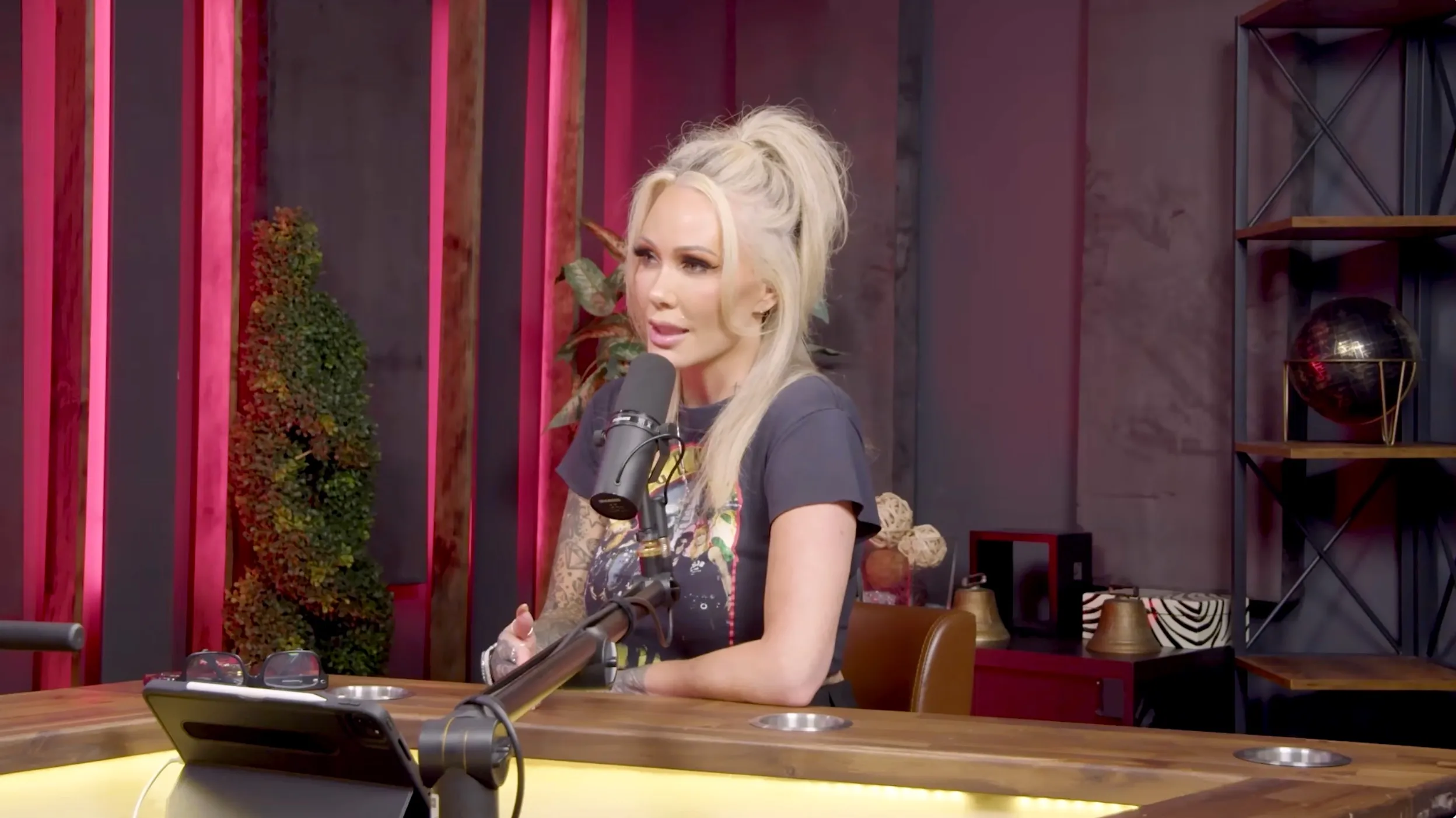 Bunnie Xo speaking into a microphone at a table.