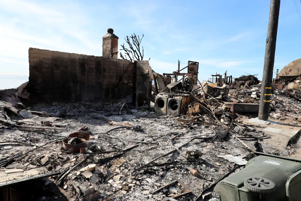 The burnt home of TV producer Peter Lenkov, with debris scattered everywhere, and the ocean visible in the background.