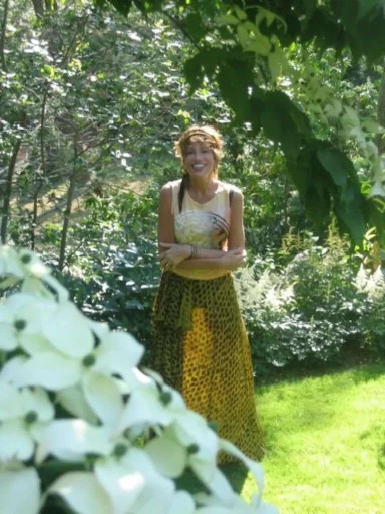 Carly Simon posing in a garden.