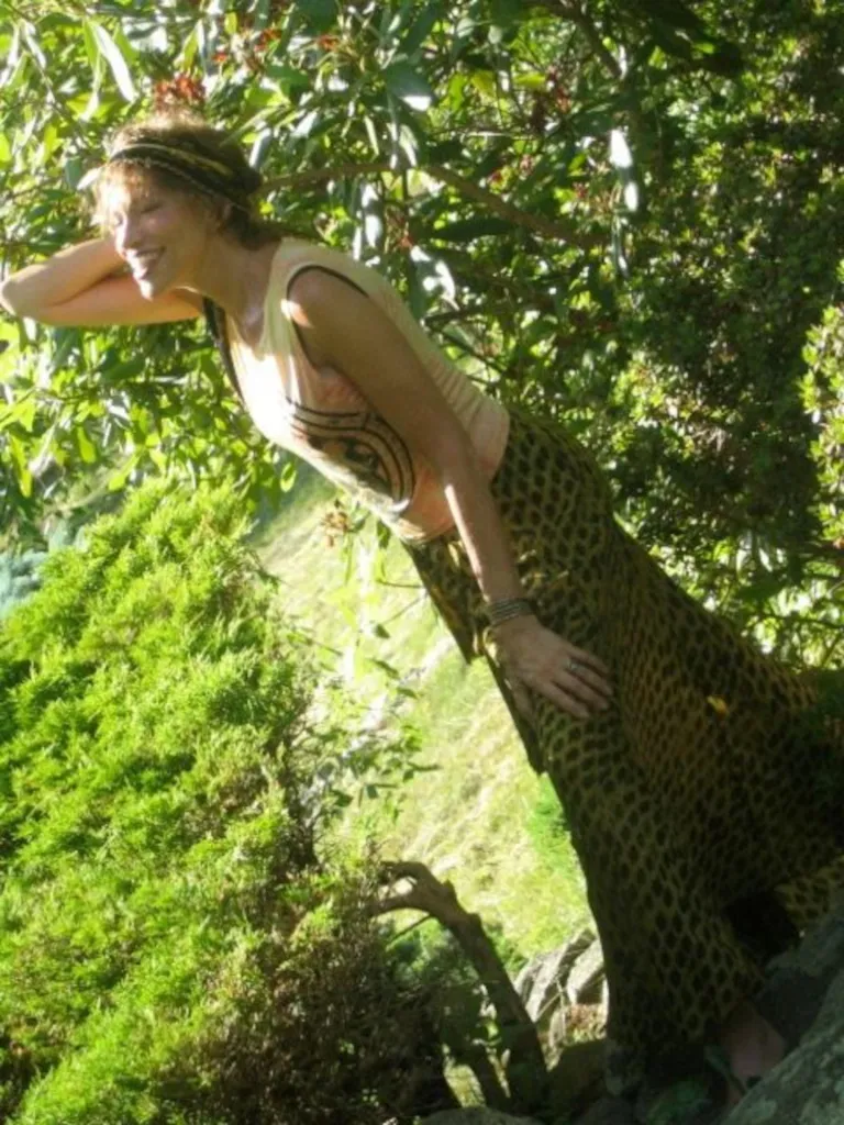 Carly Simon posing in a wooded area.