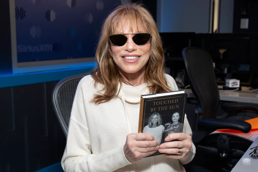 Carly Simon holding her book "Touched by the Sun" at SiriusXM Studios.