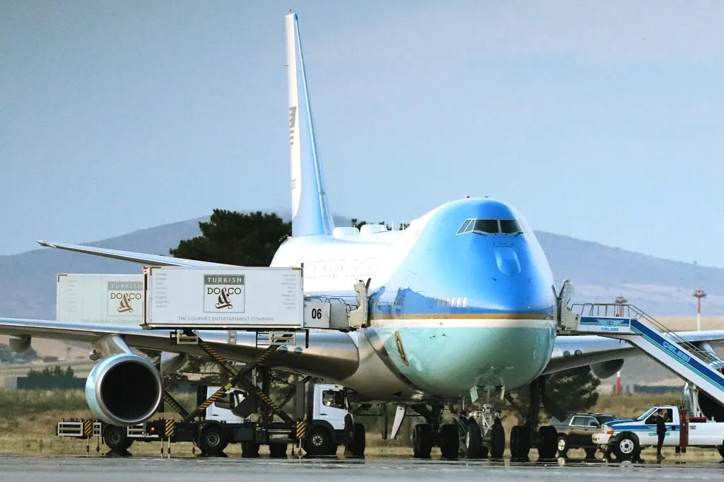 Air Force One at Ankara International Airport with catering trucks parked alongside.