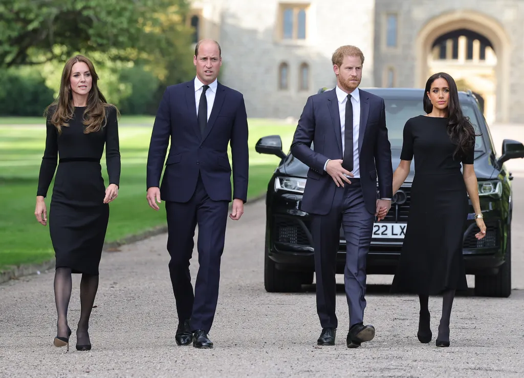 The Prince and Princess of Wales with the Duke and Duchess of Sussex, dressed in black, walking along the Long Walk at Windsor Castle.
