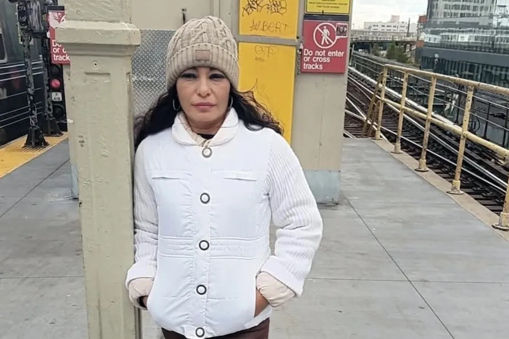 Erika Miranda, dressed in a white jacket and beanie, standing on a subway platform.