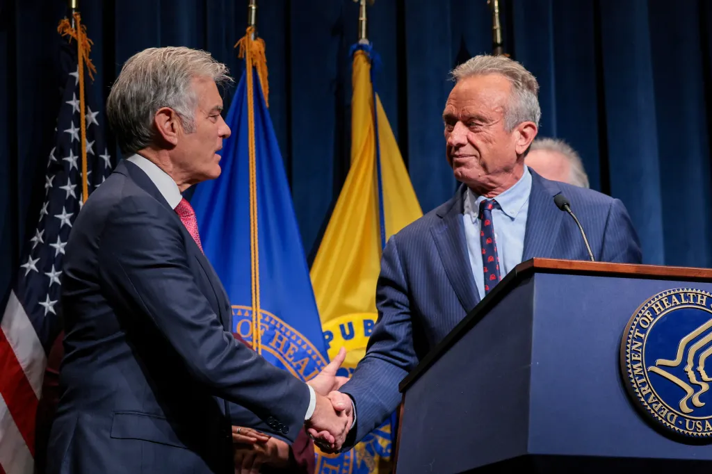 U.S. Secretary of Health and Human Services Robert F. Kennedy Jr. and Center for Medicare & Medicaid Services Administrator Dr. Mehmet Oz shake hands at a press conference.