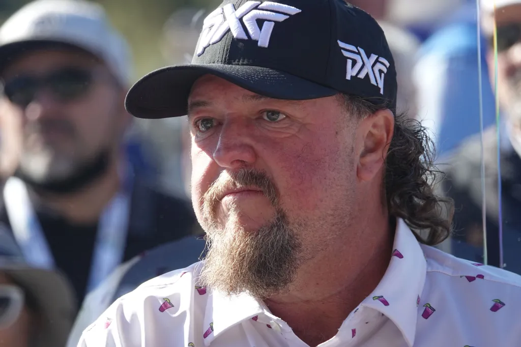 Colt Ford wearing a black PXG baseball cap and a white patterned shirt.