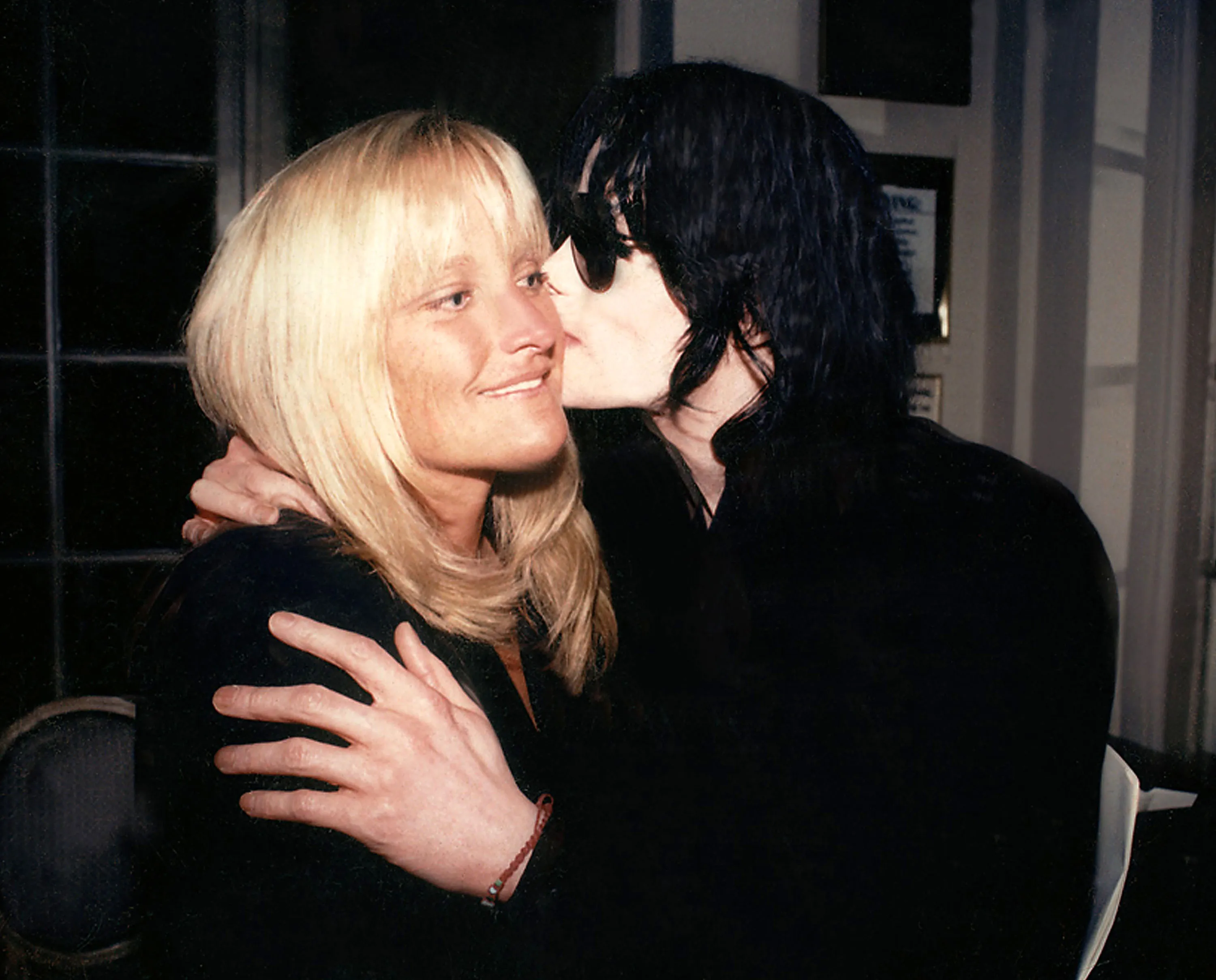 Debbie Rowe and Michael Jackson share a kiss.