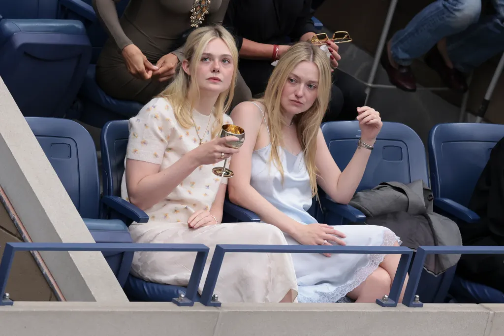 Elle Fanning and Dakota Fanning sitting together in the stands at the US Open.