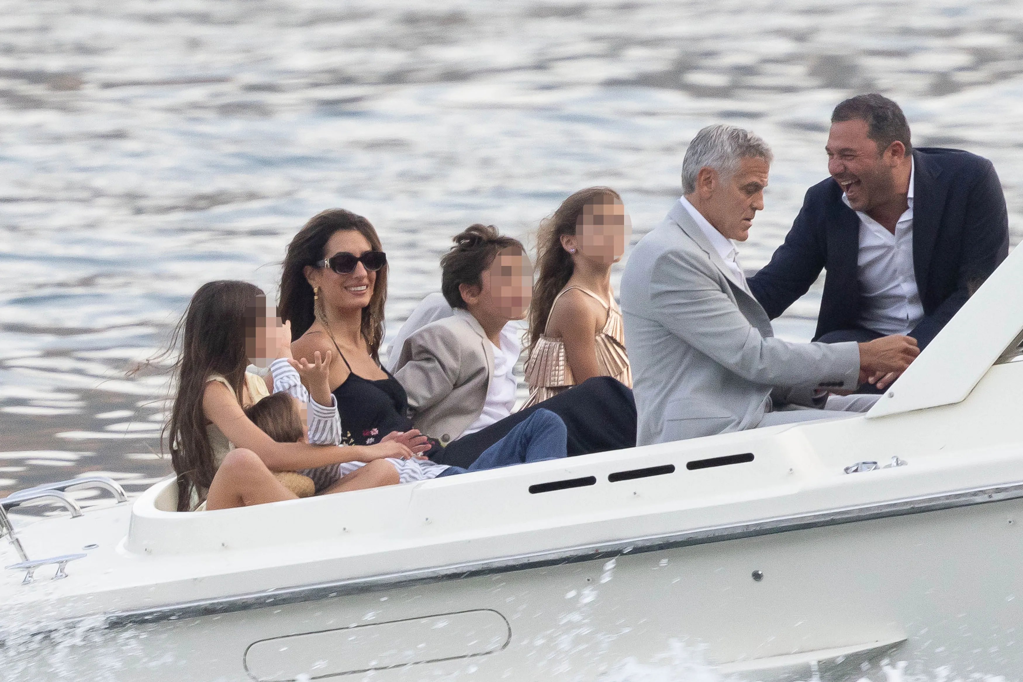 George and Amal Clooney with Ella and Alexander Clooney arriving by boat to a fundraiser.