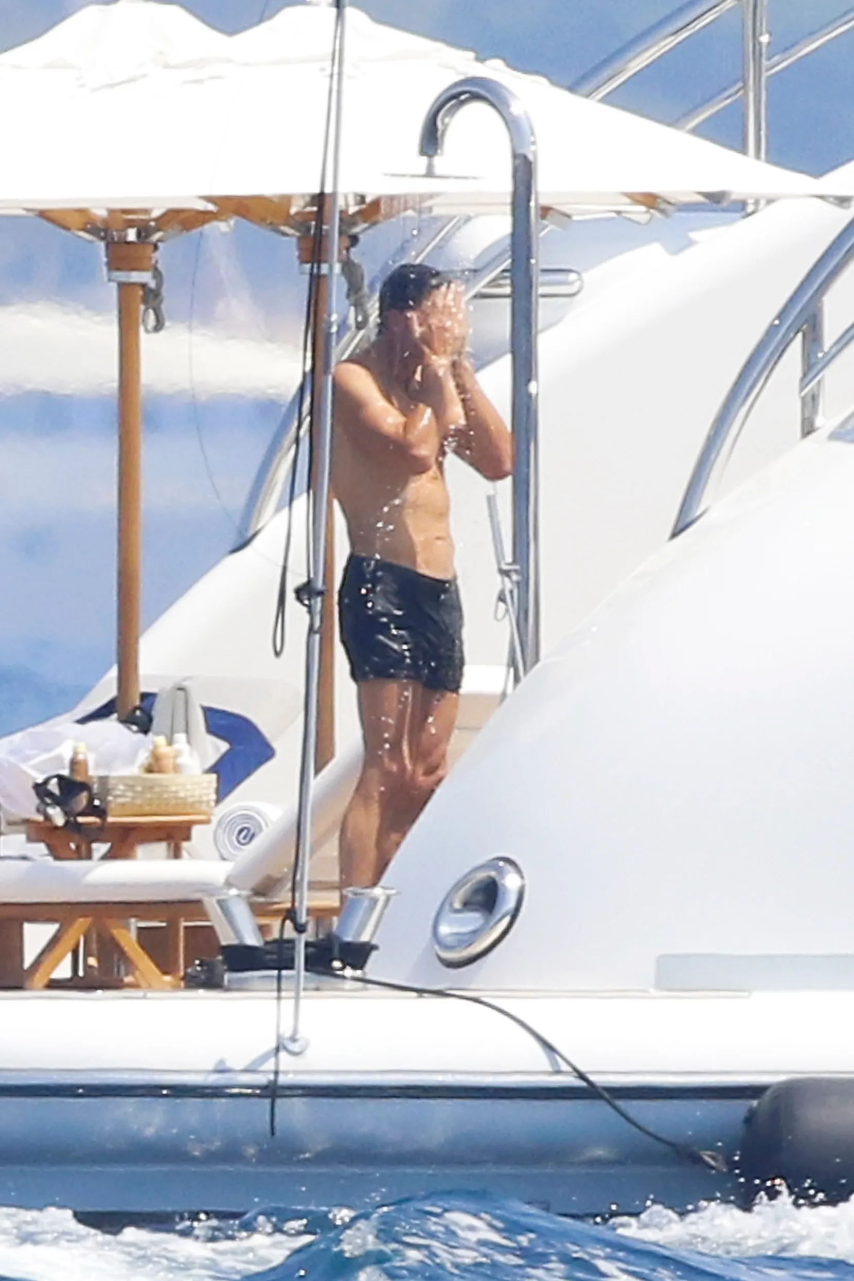 Tom Brady rinsing off in an outdoor shower on a yacht.