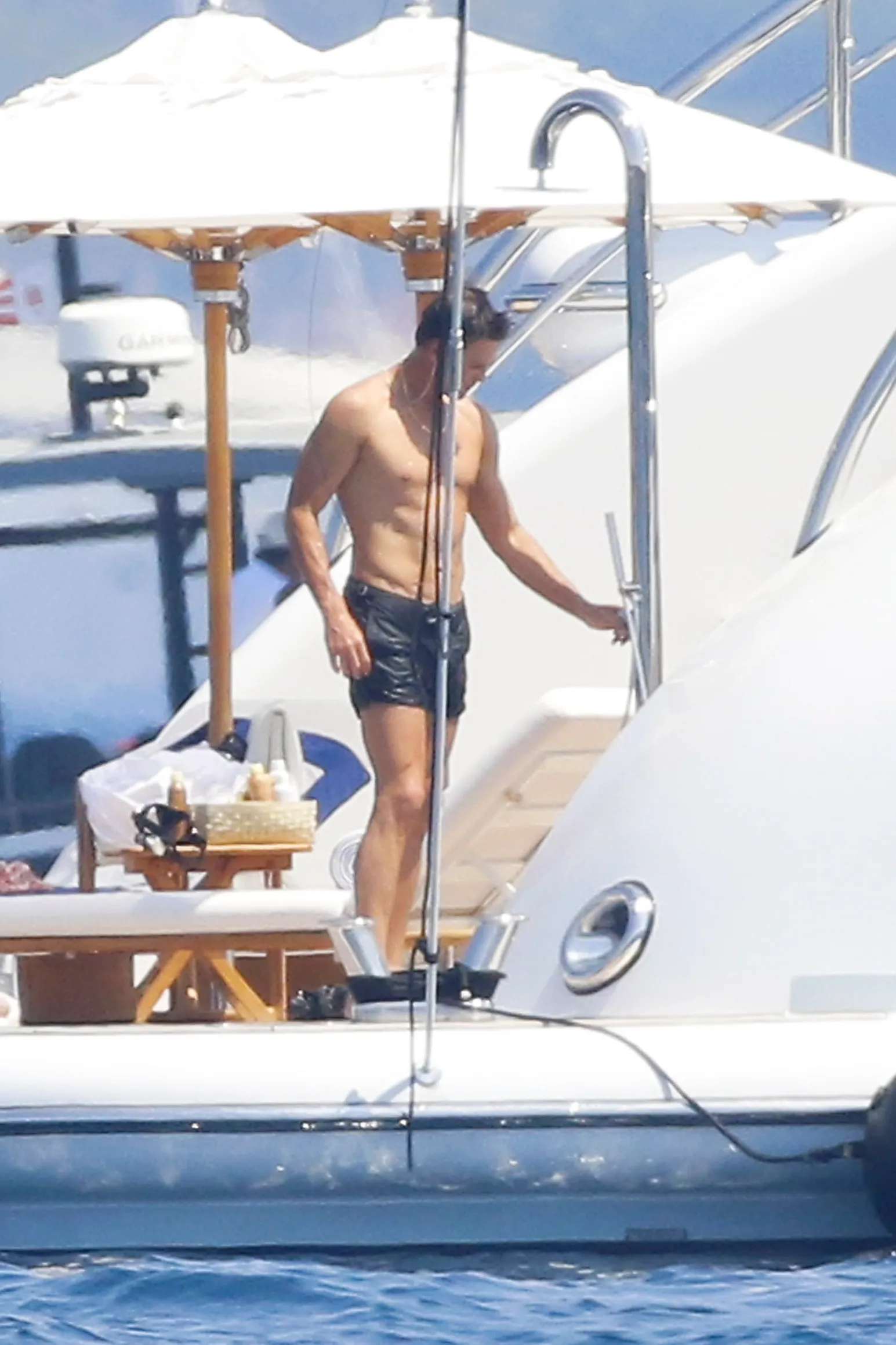 Tom Brady climbing out of the water onto a yacht in the South of France.