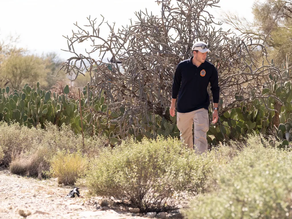 FBI officer searching for clues in a desert landscape.
