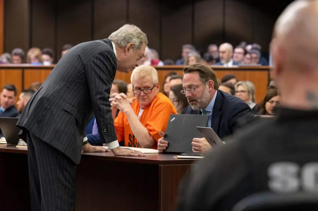 Alex Murdaugh, in an orange jumpsuit, listens to his attorneys Dick Harpootlian and Phil Barber at a judicial hearing.