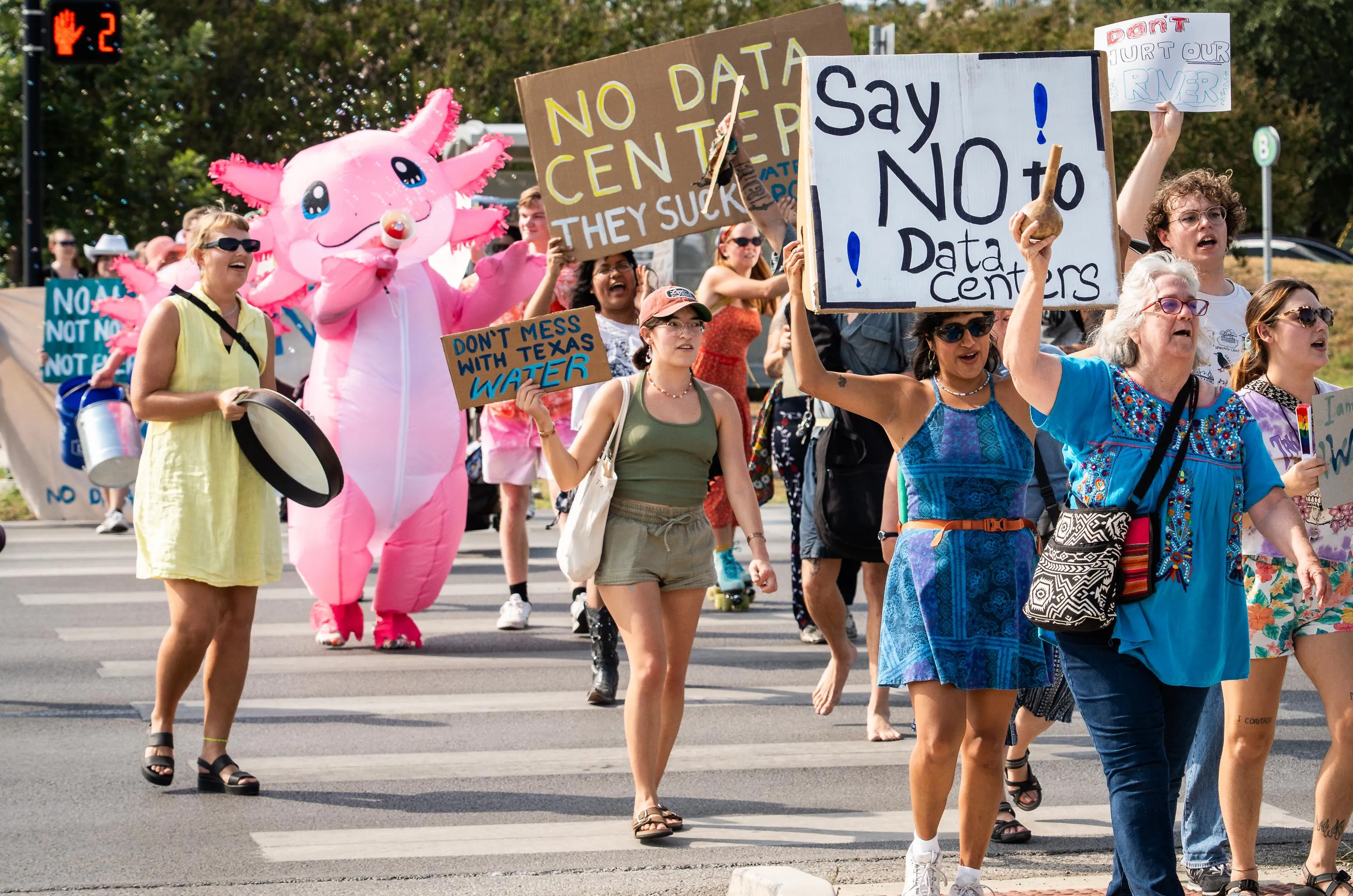 SAN MARCOS, TEXAS - AUGUST 19: Protesters walk together in the March for Water and a Sustainable Future, Aug. 19, 2025. Activists marched for San Marcos City Park to City Hall to protest proposed data centers in the area. (Sara Diggins/The Austin American-Statesman via Getty Images)