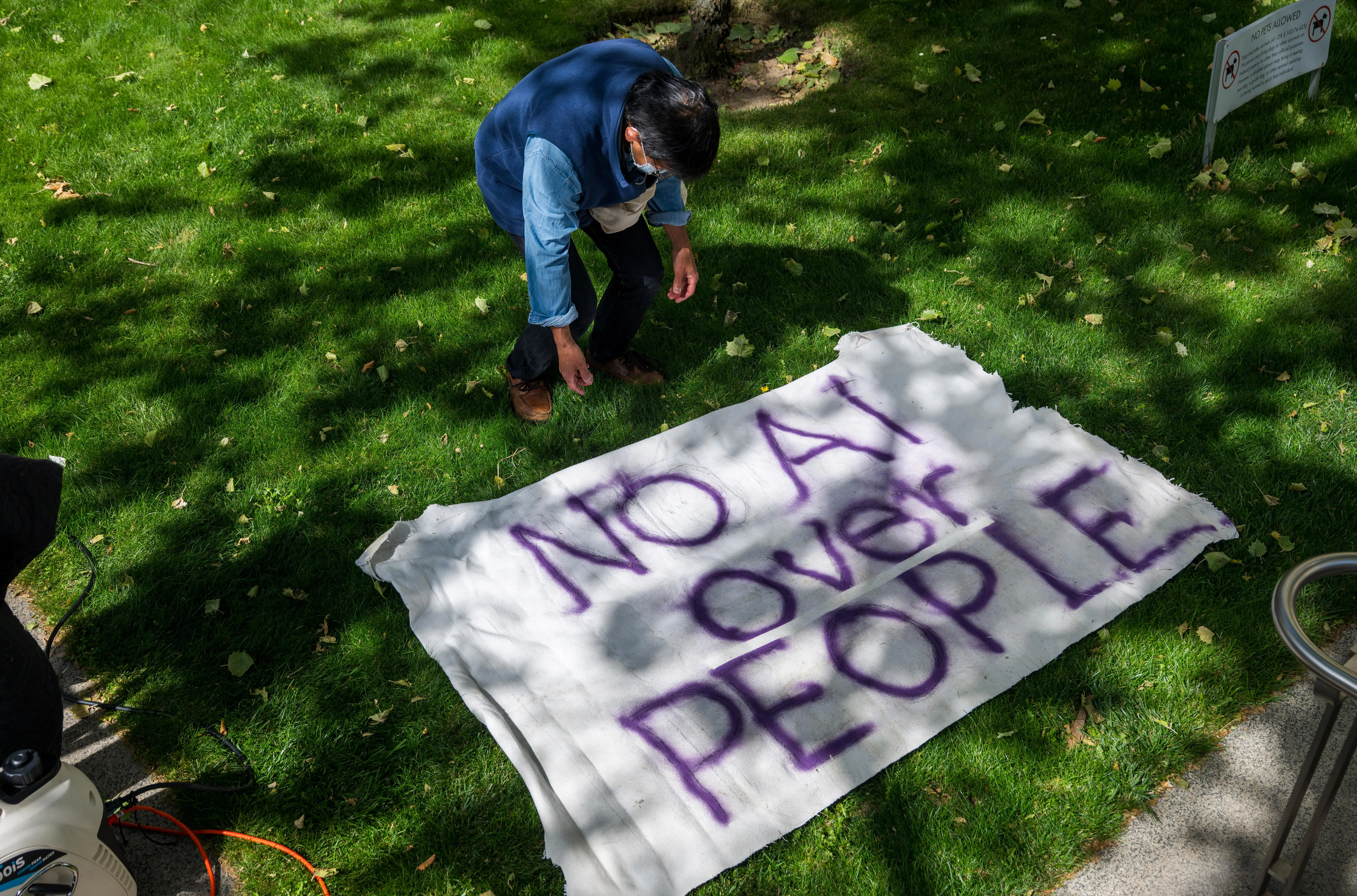 A demonstrator sets up a protest sign against AI outside federal court in Oakland, California, US, on Monday, April 27, 2026. Elon Musk is suing OpenAI and Microsoft Corp. over claims that the startup abandoned its founding mission when it took billions of dollars in backing from the software stalwart and planned its restructuring. Photographer: Nic Coury/Bloomberg via Getty Images