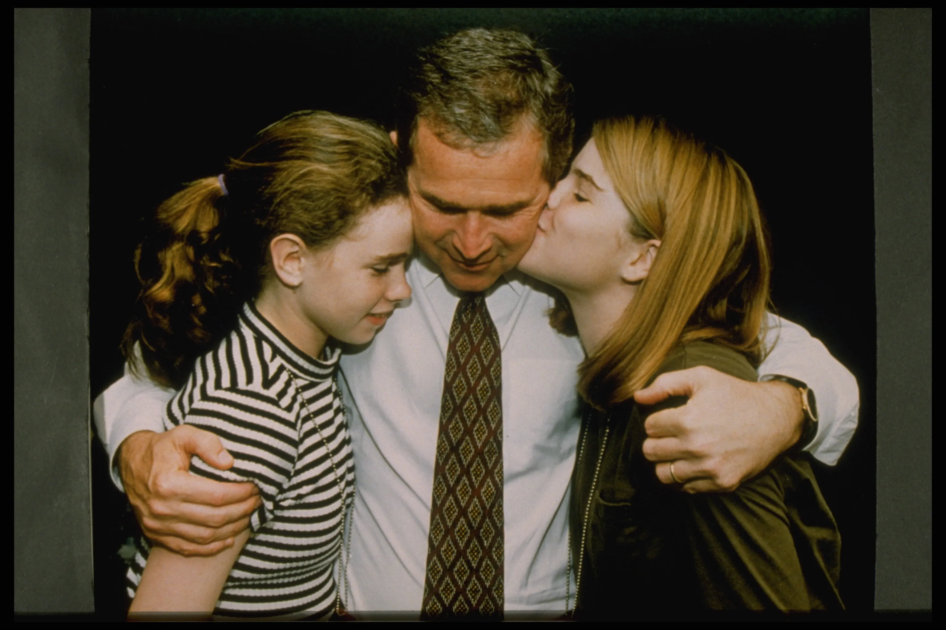 George W. Bush hugging his daughters Barbara and Jenna.