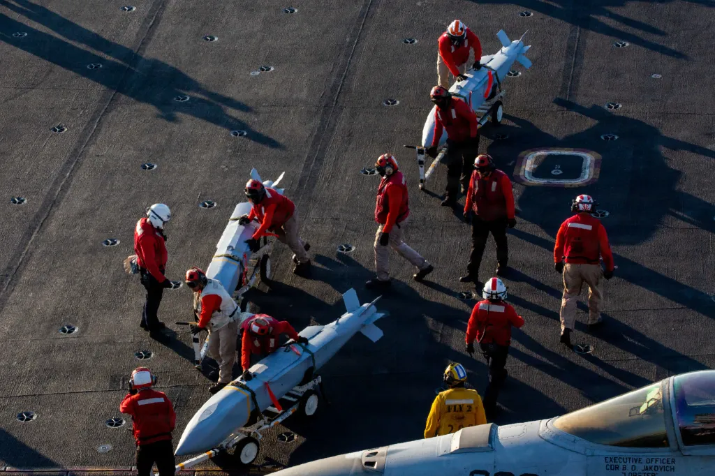 U.S. Sailors moving ordnance on the flight deck of the USS Abraham Lincoln aircraft carrier.