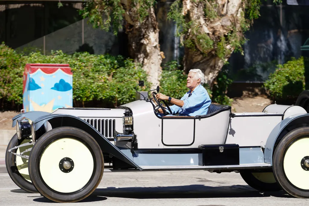 Jay Leno driving a vintage car in Los Angeles.