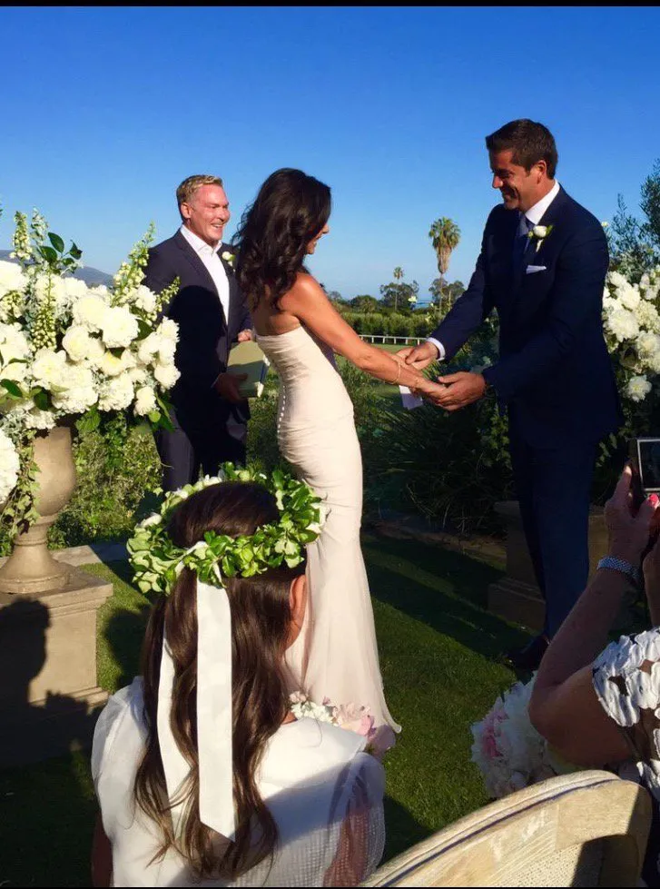 Josh Elliott and Liz Cho holding hands during their wedding ceremony.