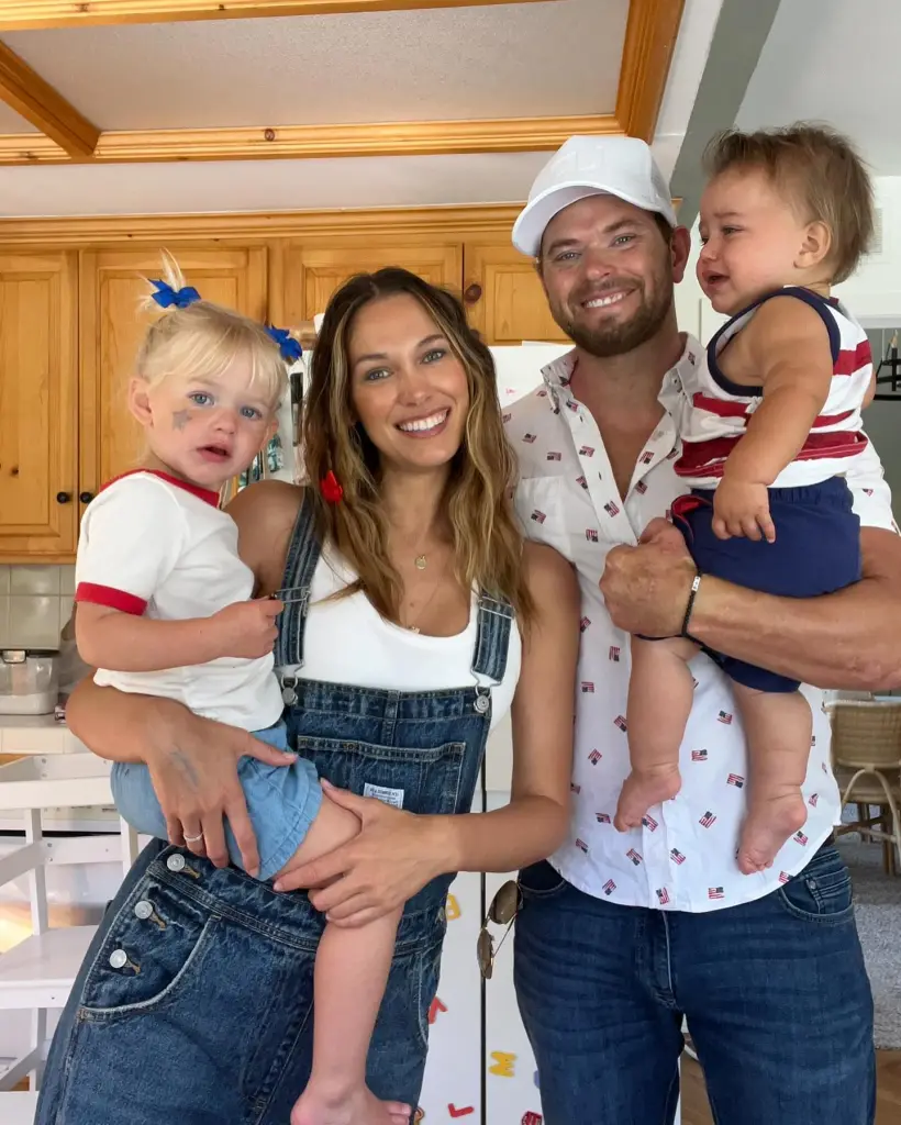 Kellan Lutz, his wife, and two children posing for a photo.