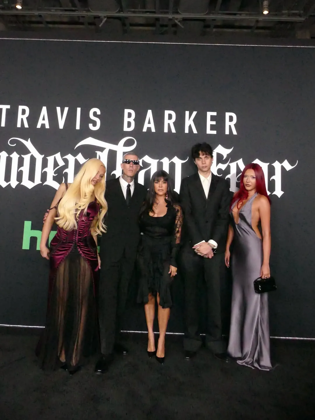 Kourtney Kardashian, Travis Barker, and their family dressed in black and dark colors.