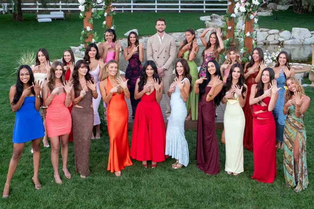 Cast of "Harry & Meghan: An African Wedding" on Netflix, with a man in a beige suit surrounded by women in colorful dresses, all showing their left hands.