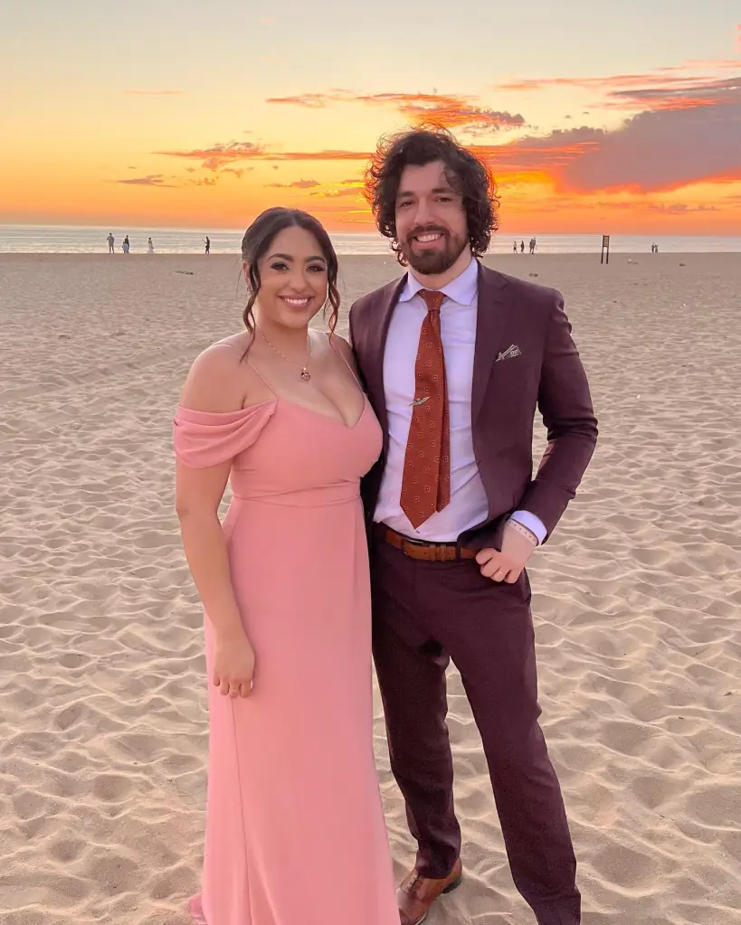 Bliss Poureetezadi and Zack Goytowski on a beach at sunset.