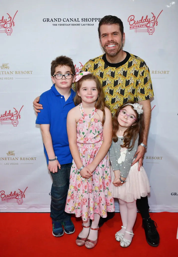 Perez Hilton with his three children, Mario, Mia, and Mayte, on a red carpet.