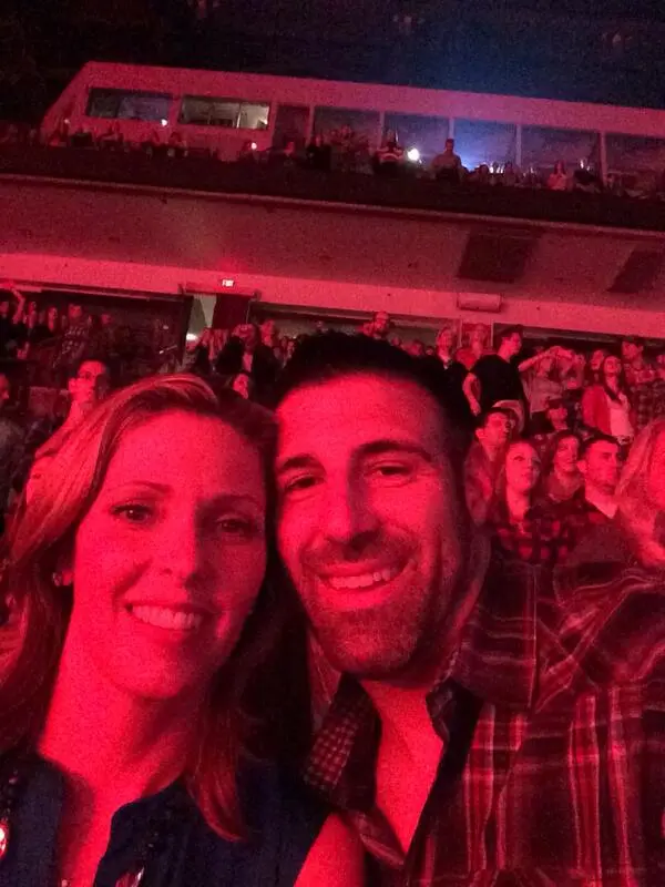 Mike Vrabel and wife Jen taking a selfie in a red-lit venue.