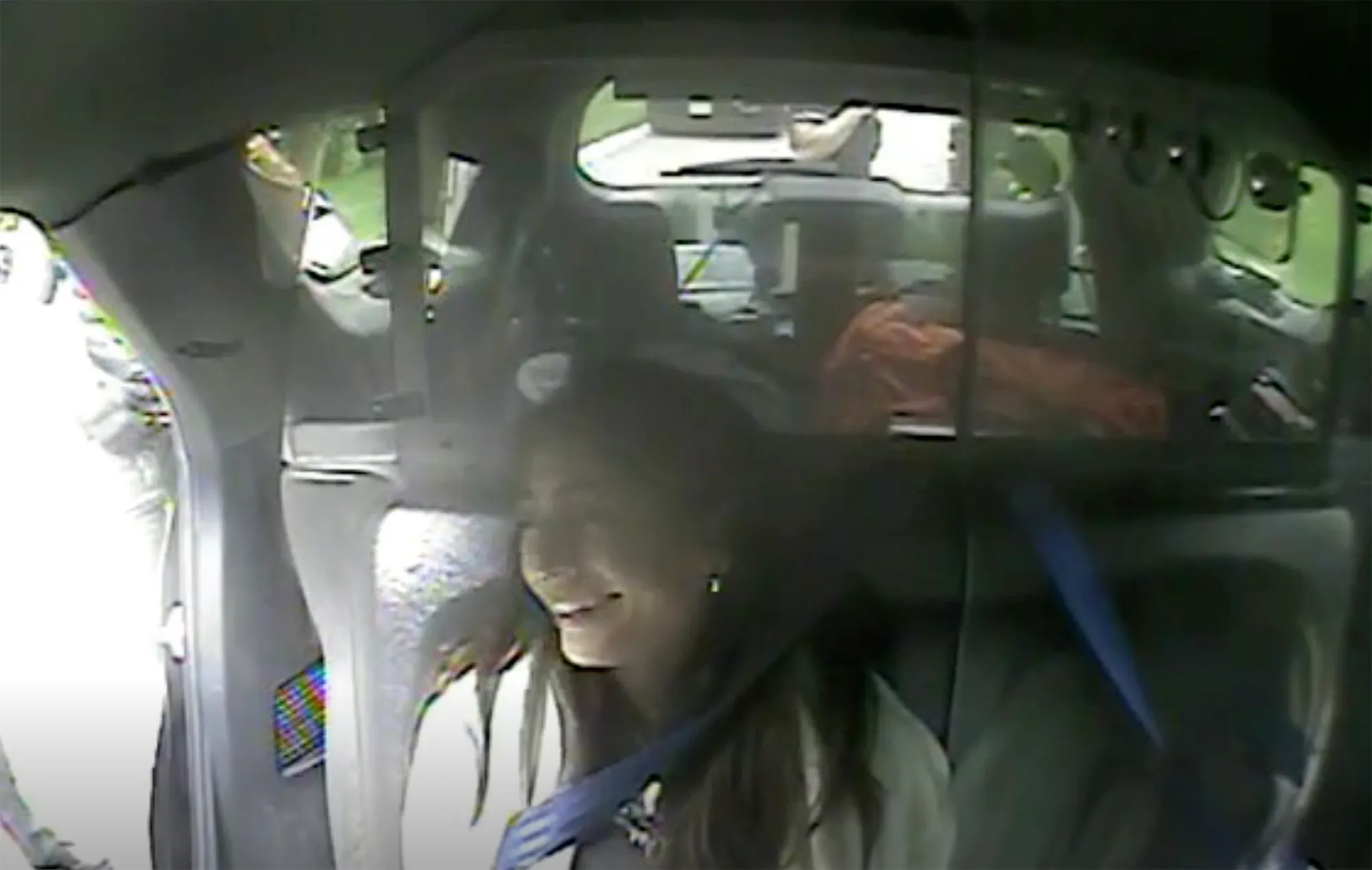 Milania Giudice laughing as an officer puts on her seatbelt.