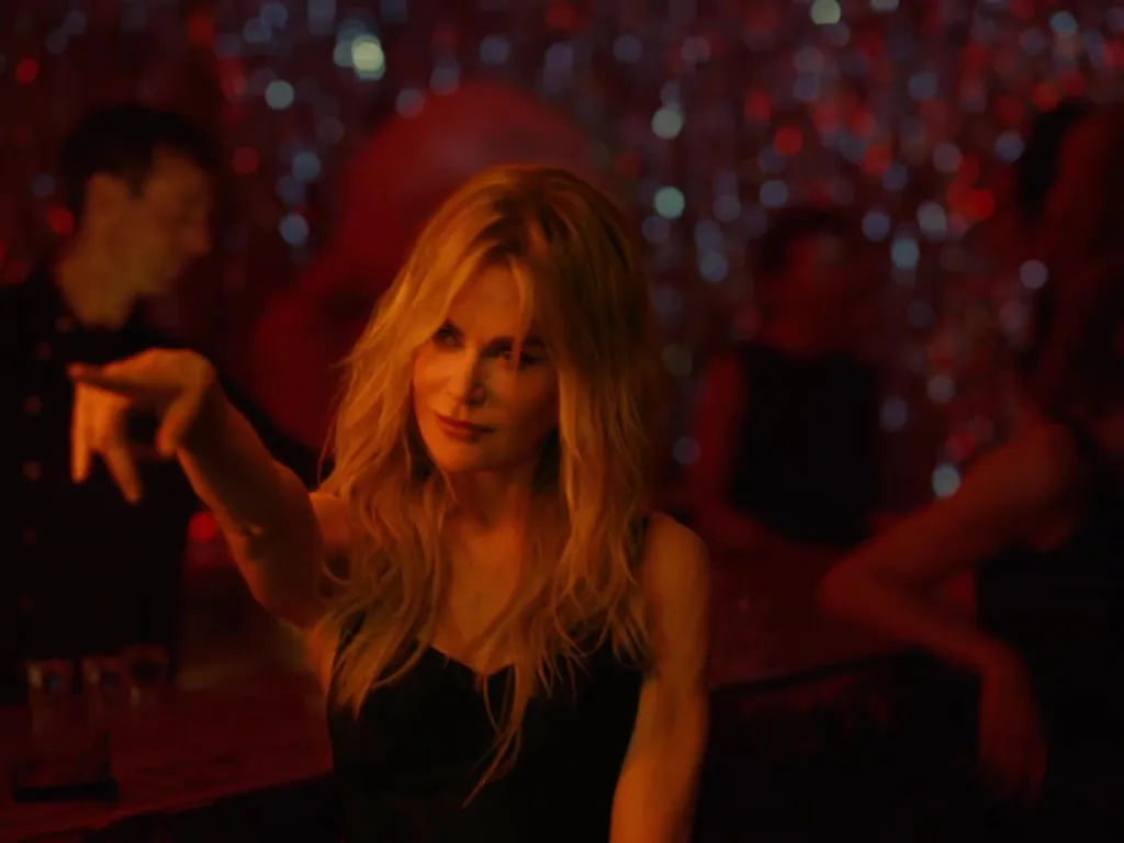 Nicole Kidman dancing in a nightclub, pointing her finger.