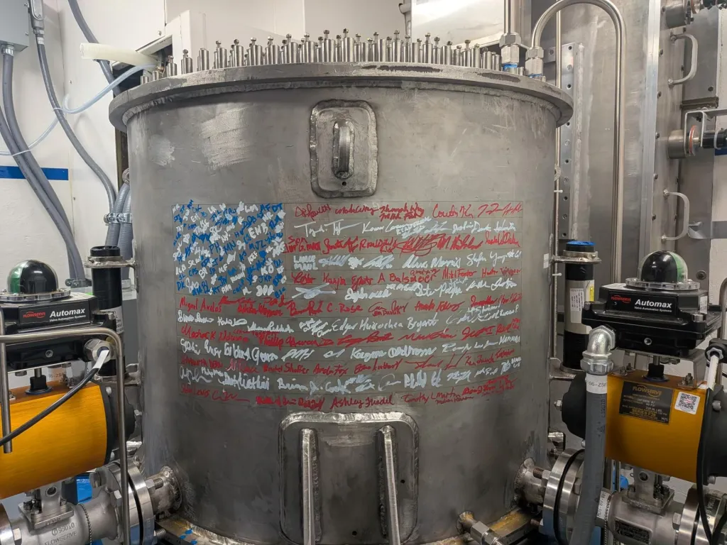 Large metal container with an American flag of signatures written on its side, representing novel technologies being developed to power AI.