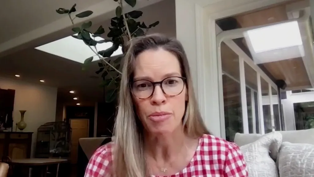 Hilary Swank in a red and white checkered top.