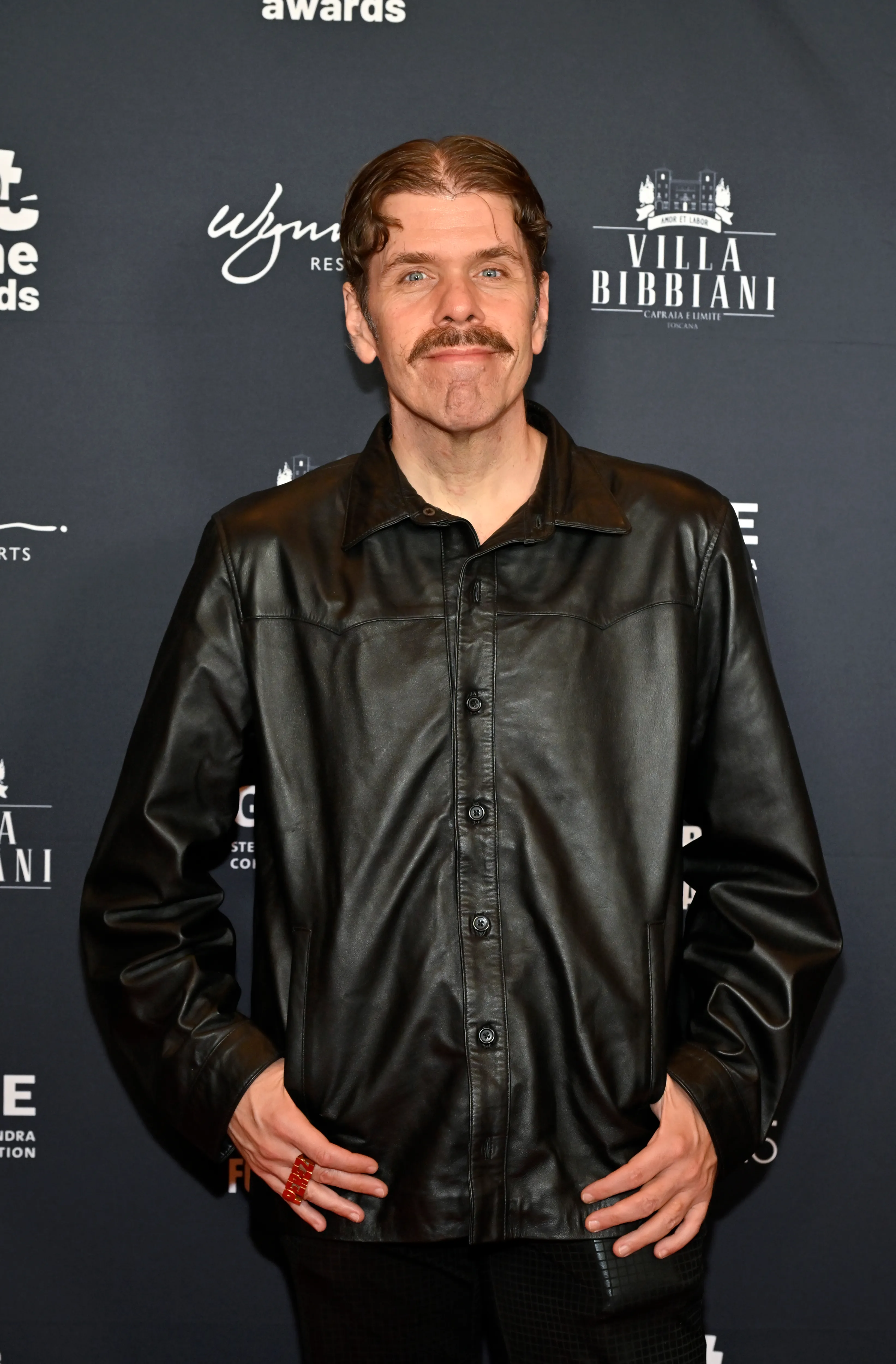 Perez Hilton in a black leather shirt and red ring at the Not Alone Awards.
