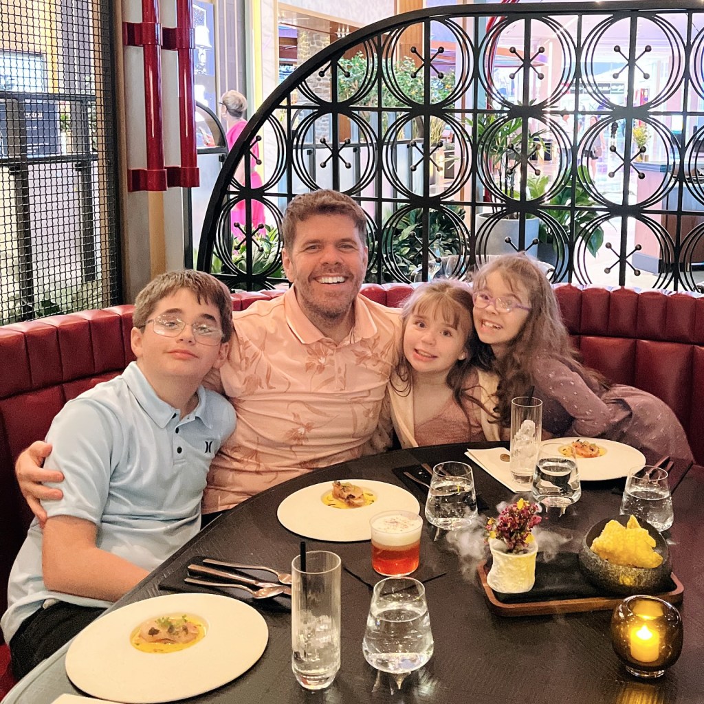 Perez Hilton with his three children in a restaurant.