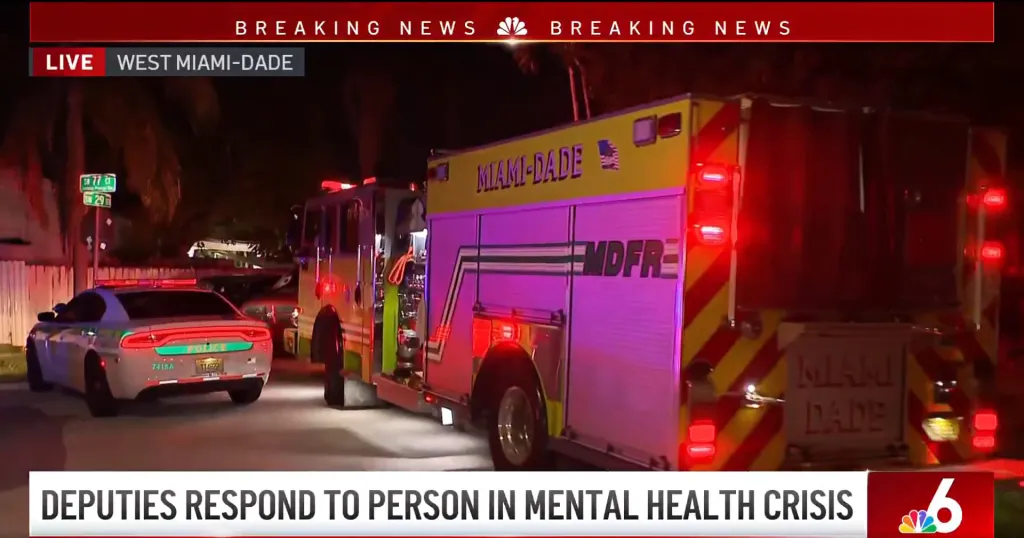 Police car and fire truck with flashing lights on a street at night.