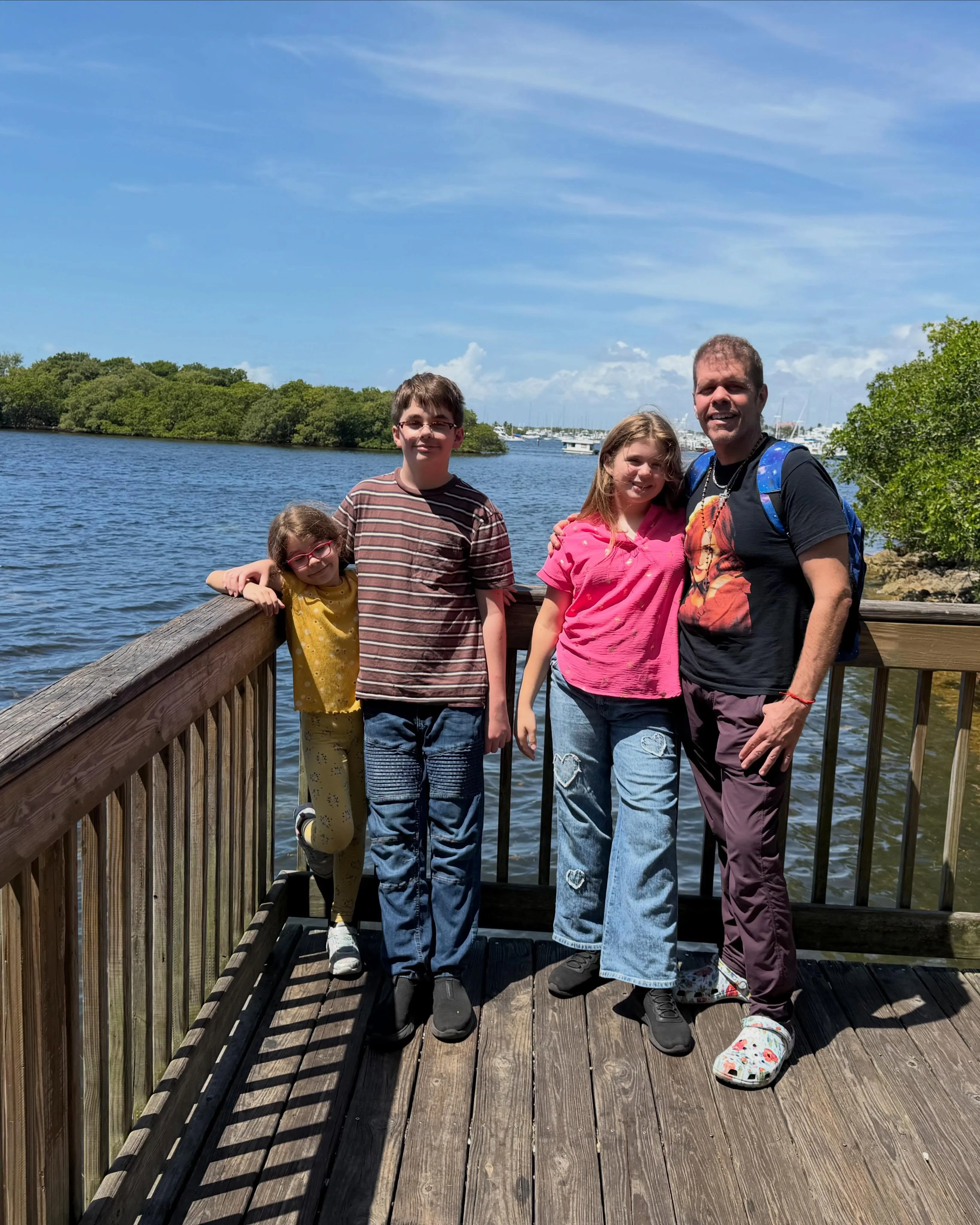 Perez Hilton with his three children on a dock.