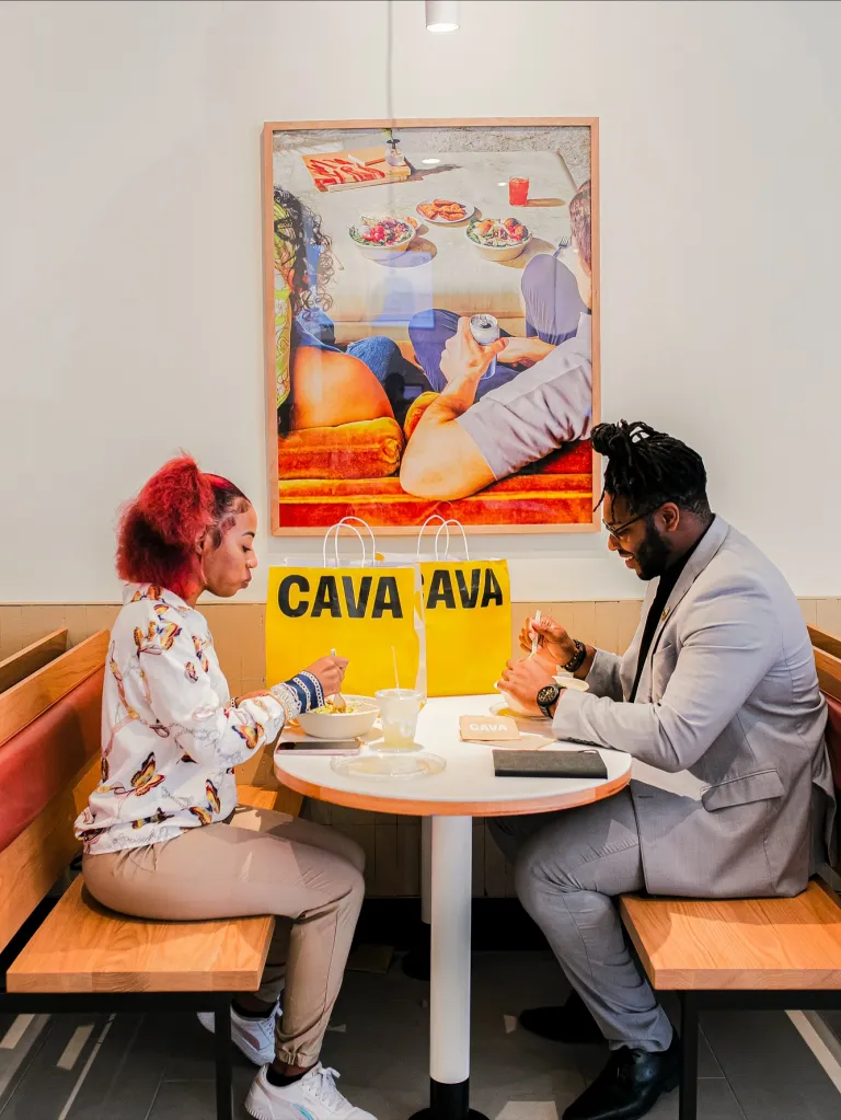 Two people eating at Cava, a Mediterranean fast-casual chain.
