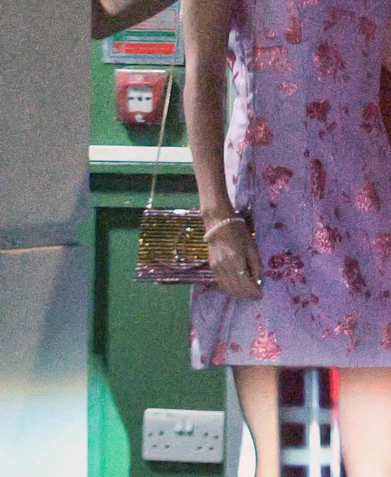 Taylor Swift in a pink and purple floral print mini slip dress, gold shoulder bag, and metallic strappy heels.