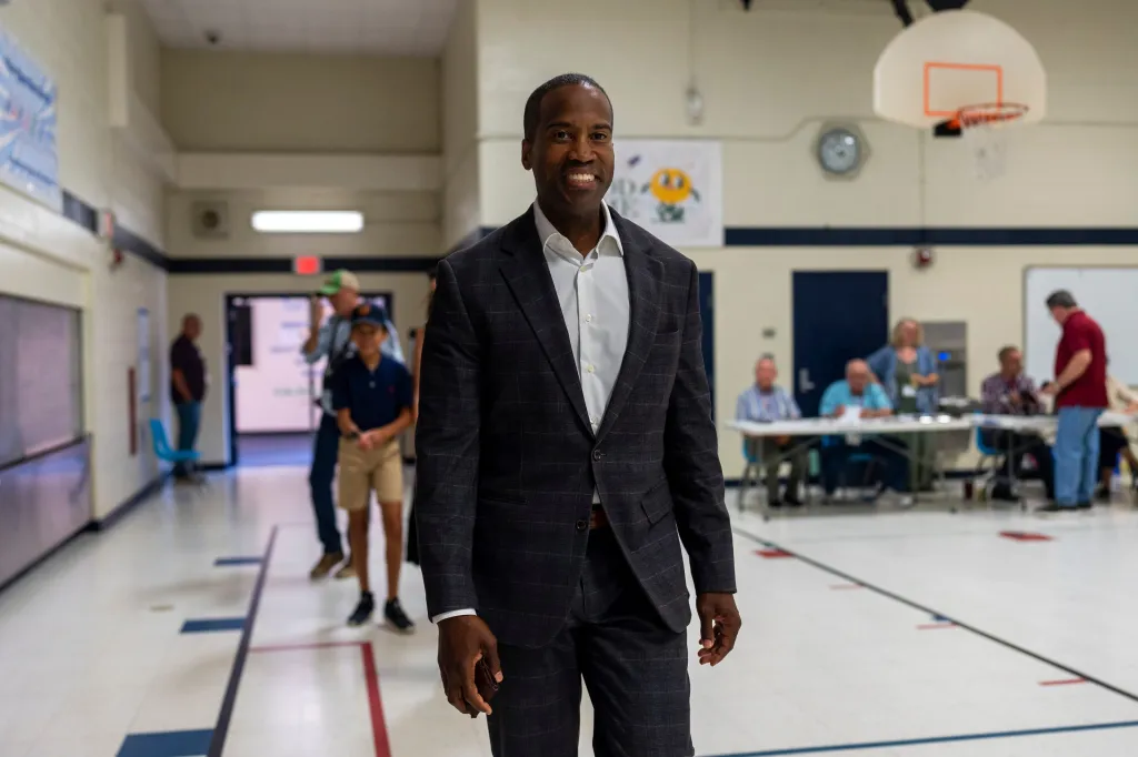 Republican gubernatorial candidate and U.S. Rep. John James smiles as he walks into Morgan Elementary School to cast his ballot.