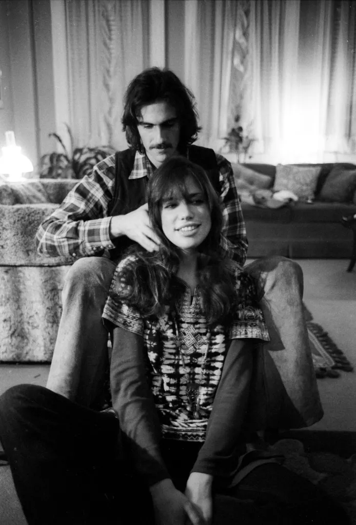 Carly Simon and James Taylor posing for a portrait in their home.